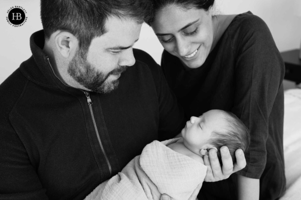 parents hold baby son in arms