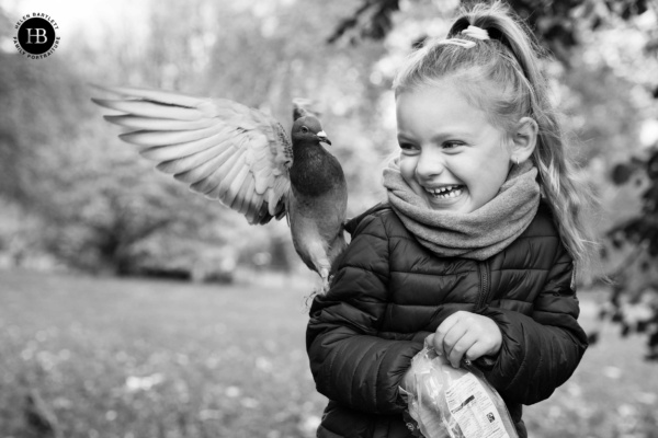 Black and white family photography of a girl and London pigeons.