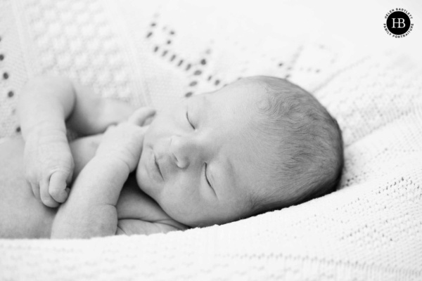 Sleeping newborn photographed in natural black and white during an at-home portrait session in London