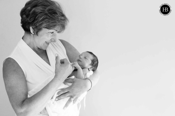 Grandparent holding a newborn baby during a family photography session at home