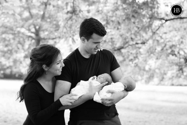 Twins and their parents photographed outdoors during a home newborn session on a fine day