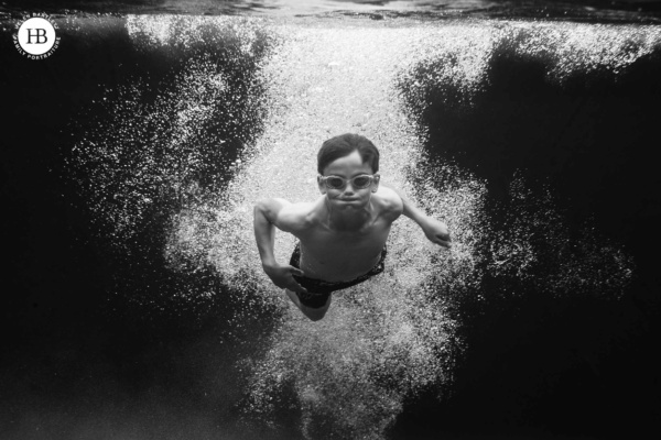 teenage boy swims through bubbles