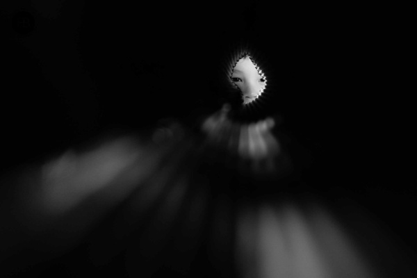 boy looks through cardboard tube shot in monochrome