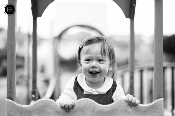 Portrait of two year old girl laughing while playing on the climbing frame