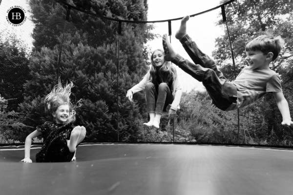 children jump on trampoline during family photo shoot in beaconsfield