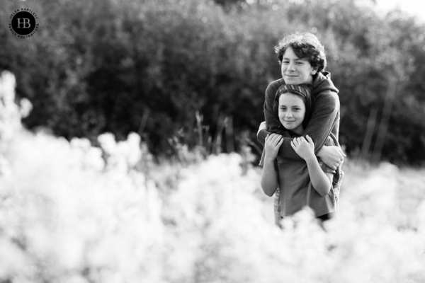 Two teenagers hug on a spring family photo shoot in Regents Park in London