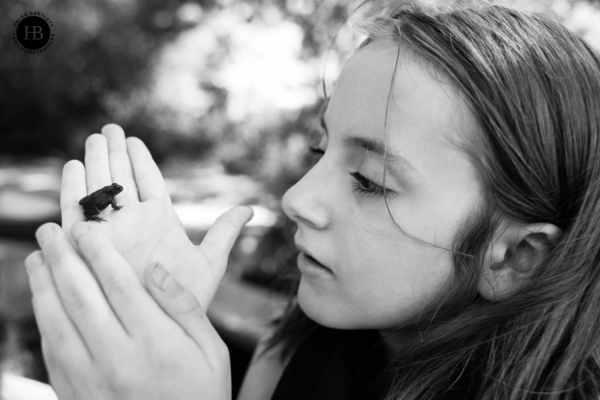 girl-holds-tiny-frog-on-family-photography-session-cotswolds