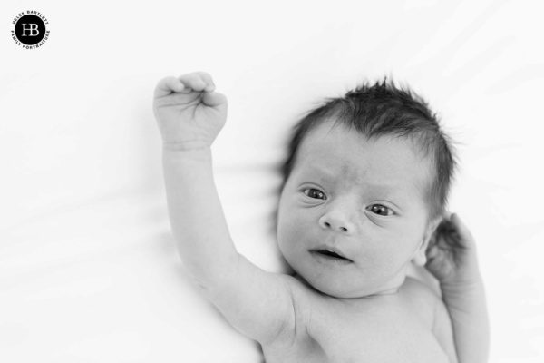 newborn-baby-waves-hello-with-smile