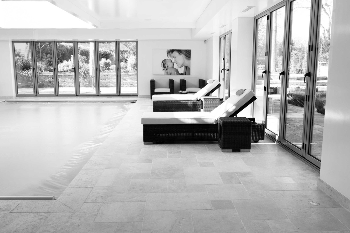 An aluminium framed family portrait of a mother and newborn in a pool room.