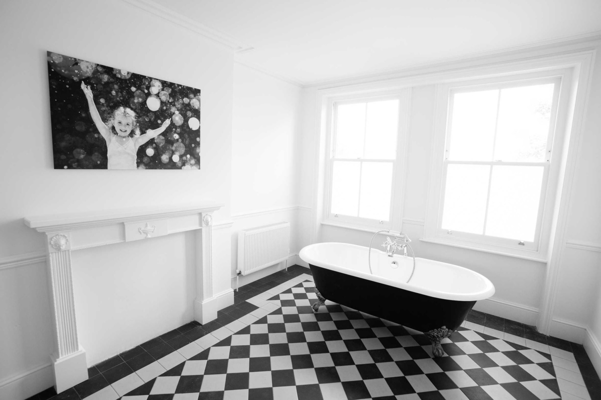 An aluminium framed photo of a girl and water droplets in a bathroom.