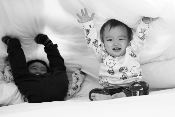 Babies giggle in bed.