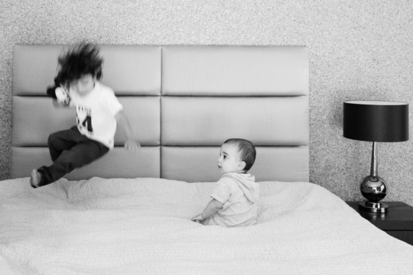 A baby and sibling share a bed.