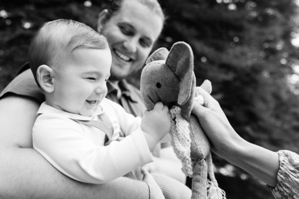 Baby giggles at elephant toys, while with his parents.