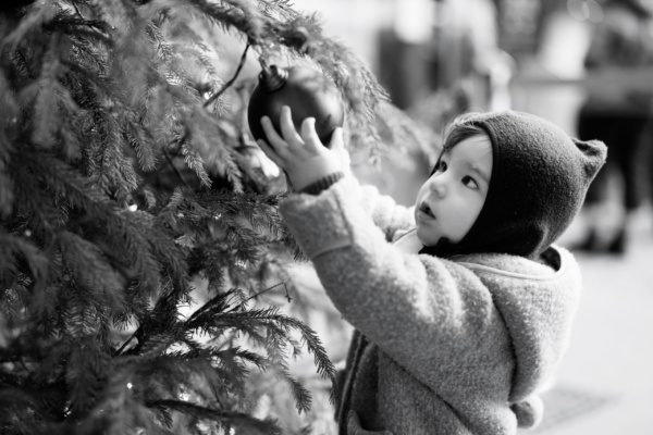 A baby holds a Christmas decoration during a Christmas shoot in London's Covent Garden.