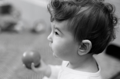 Baby holds a round toy.