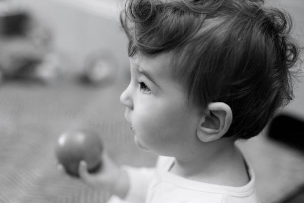 Baby holds a round toy.