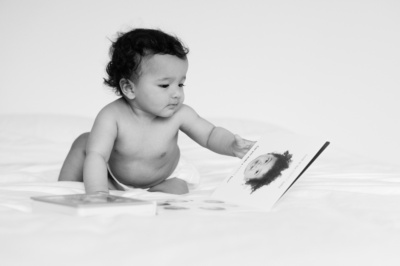 A baby looks at a book.