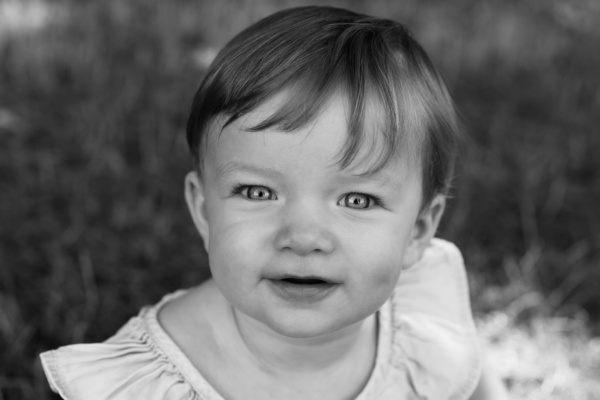 A baby looks at a camera.