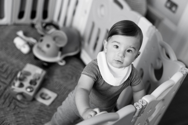 A baby looks out of his cot.