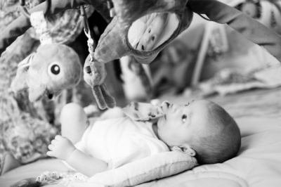 Baby looks at their own reflection in a mirror.