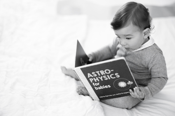 A baby reads an astro-physics book for babies.