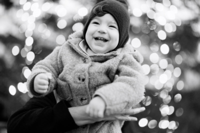 A baby is swung through the air in front of Christmas lights in London's Covent Garden.