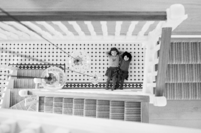 A birds-eye view of children lying on a tiled floor.