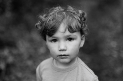 A black and white child's portrait with out of focus background.