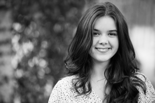 Black and white portrait of a smiling teenager.