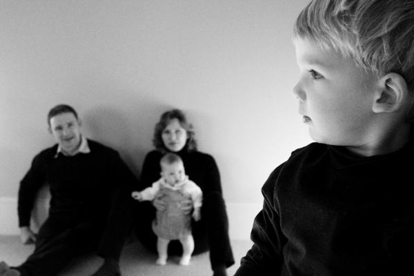 Boy in profile with his family in background.