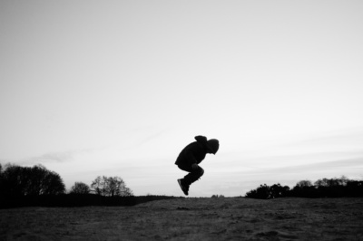 A boy jumps in a field.