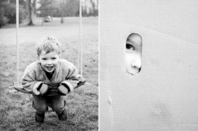 Boy plays on swing and looks out of hole in box.