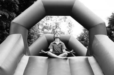 Boy relaxes at top of blow-up slide.