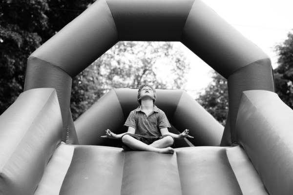 Boy relaxes at top of blow-up slide.