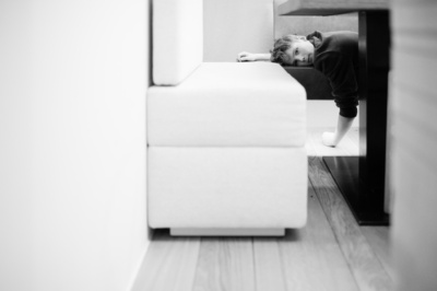 Boy rests on sofa.