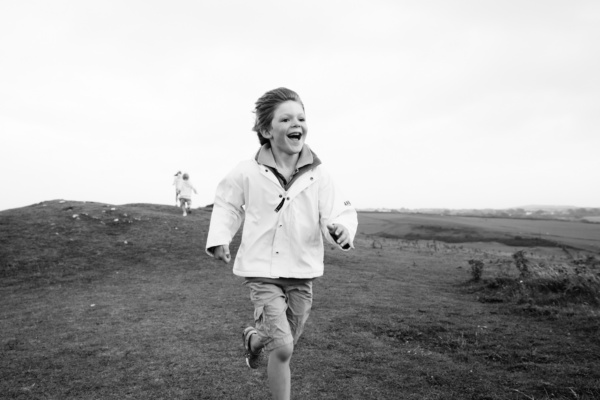 A boy runs across a field.