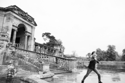 A boy runs through gardens.