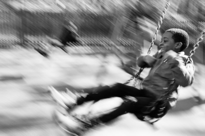 Boy swings in the park.