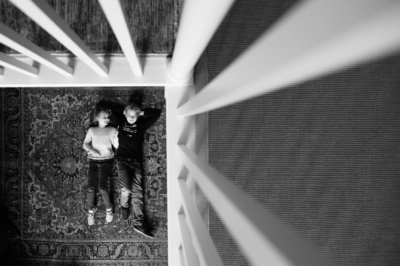 A birds eye portrait of a brother and sister on a rug.