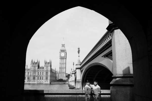 Brothers hug each other with Big Ben and the Houses of Parliament in the background.