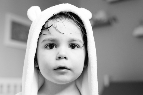 A child after a bath, wrapped in a robe.