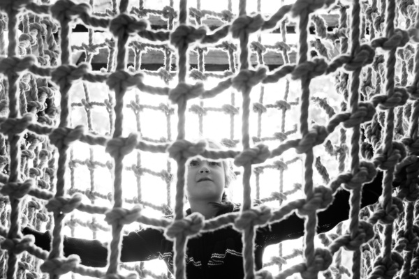 A child climbs across a rope net.