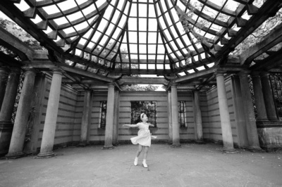 A girl dances in an outdoor gazebo.