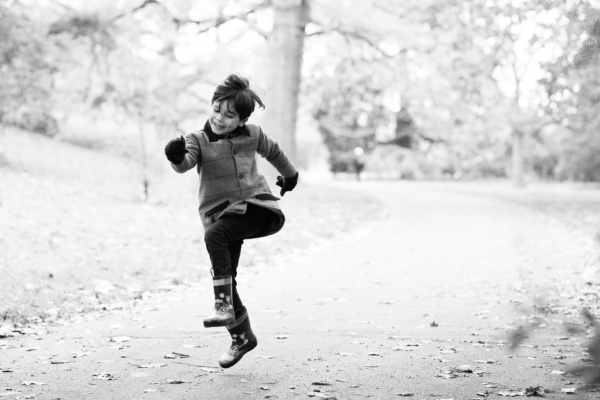 A chid skips down a park path.