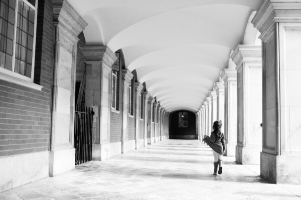 A child dances near square columns.