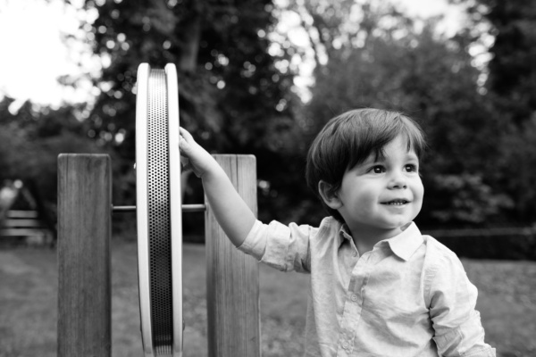 A child leans against equipment in a playground.