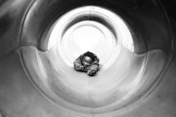 Child leans forward in a tube.