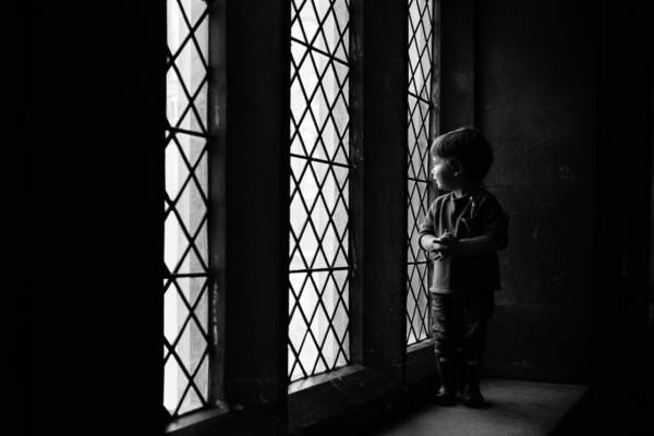 A child looks out of a narrow window.