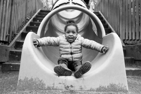 A child finishes riding down a slide.