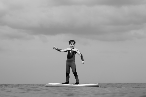 A child paddles on water on a board.